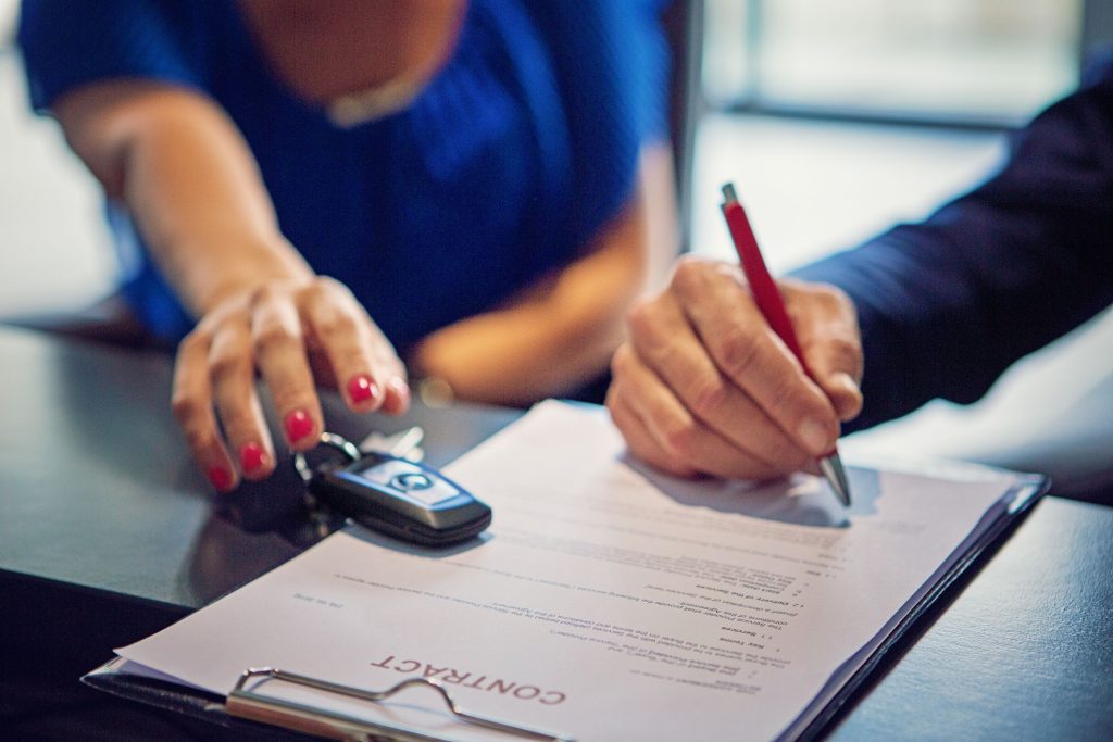 Couple signing car dealership documents