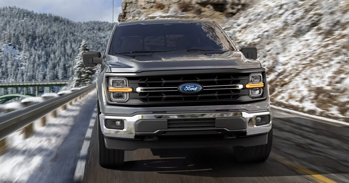 A Ford F-150 driving up a snowy mountainside